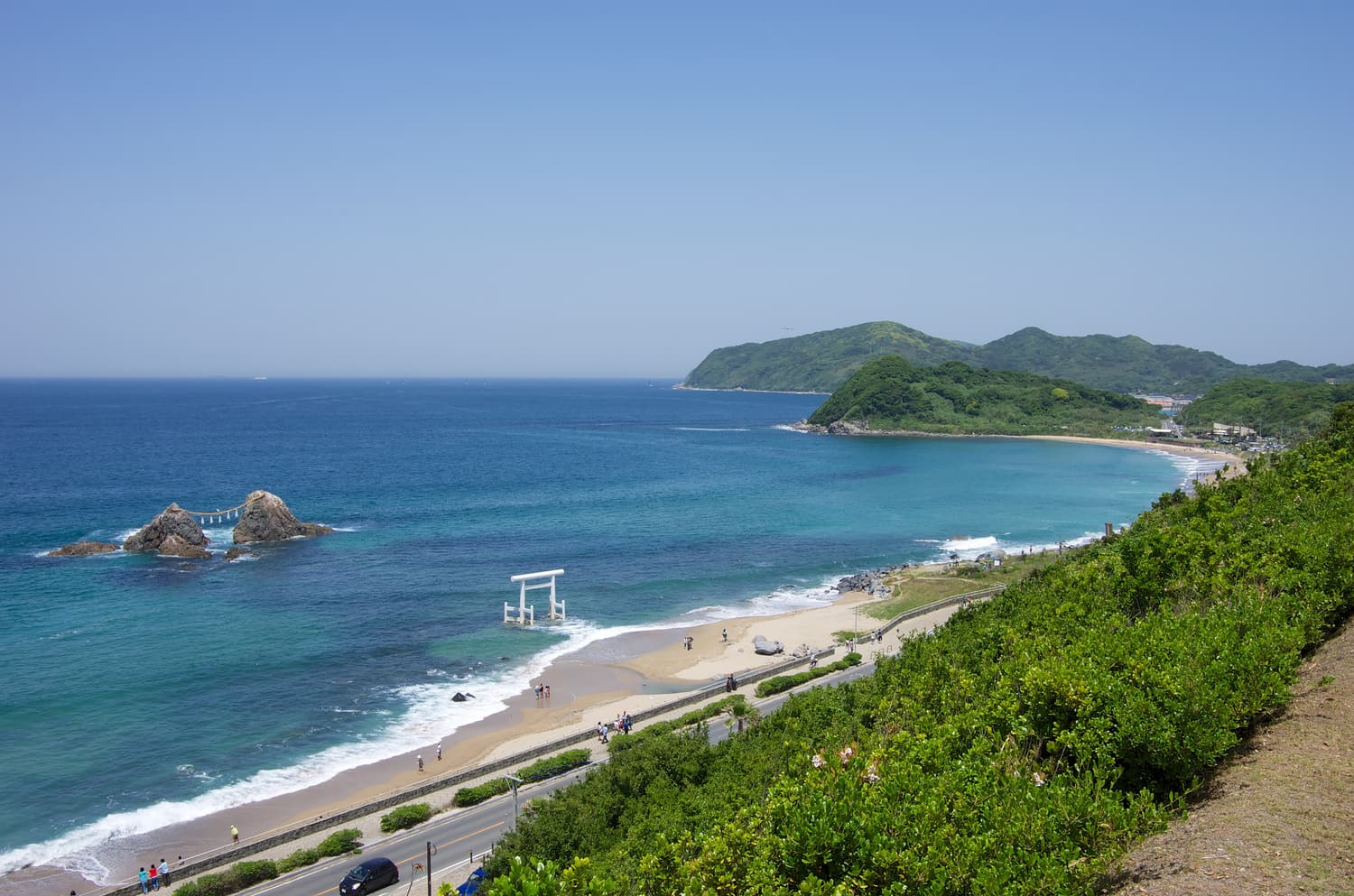 The married rocks and white torii of Sakurai Futamigaura seen from above the coast road