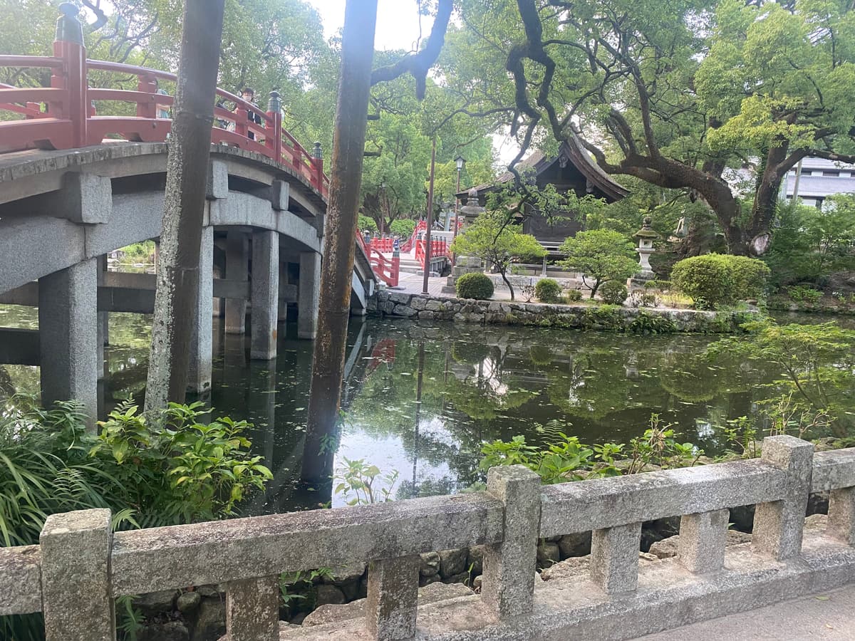 A red arched bridge over the pond at Dazaifu Tenmangu shrine